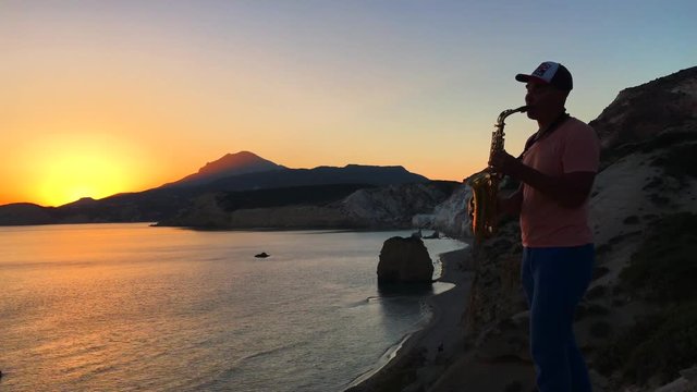 Saxophonist plays on a sunset
