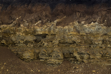 Soil cut-sandstone, stones, clay, sand structure and layers. slice of sand with layers of different structures.