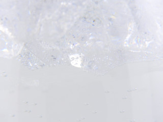 Close up of the sweet soda drink, transparent ice cubes and bubbles.gray background. Carbonated drink is liquid beverage.  Summer cool and fresh concept. With copy space.