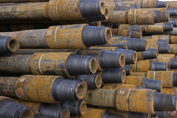 Fototapeta premium Drilling of oil and gas wells. Drill pipe inspection. Tubing for oil and gas listed on the pedestal out of the wells after washing and ready for inspection. Stack of casing laying on the deck