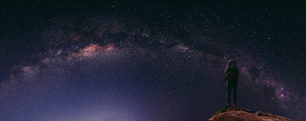 Night sky full of star and milky way, with traveller with backpack enjoying beautiful sky at night © SasinParaksa