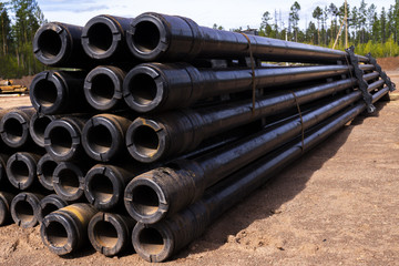 Oil Drill pipe. Rusty drill pipes were drilled in the well section. Downhole drilling rig. Laying the pipe on the deck. View of the shell of drill pipes laid in courtyard of the oil and gas warehouse.