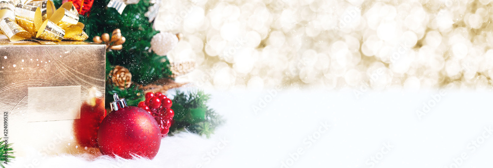 Aufkleber gift box and ball decoration under christmas tree on white fer with gold bokeh light background with snow fall.banner mock up for display of design or content.