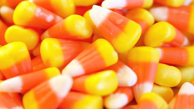 Colorful macro closeup of Halloween traditional Candy Corn treats, background.