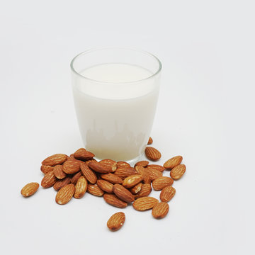 Almond milk in bottle with nuts isolated on white background