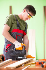 Young man carpenter working in workshop 