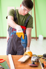 Young man carpenter working in workshop 