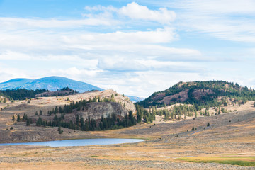 White Lake surrounded by grasslands with mountains in background in autumn