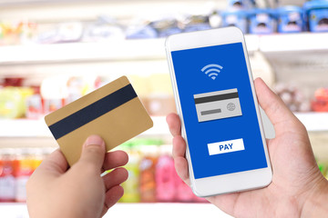 Hand holding credit card and smart phone with online payment on device screen background, shopping online, business, finance and technology, online payment, digital money concept