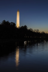 Washington Monument illuminated at night over tidal basin