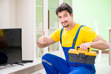 Male professional serviceman repairing tv at home