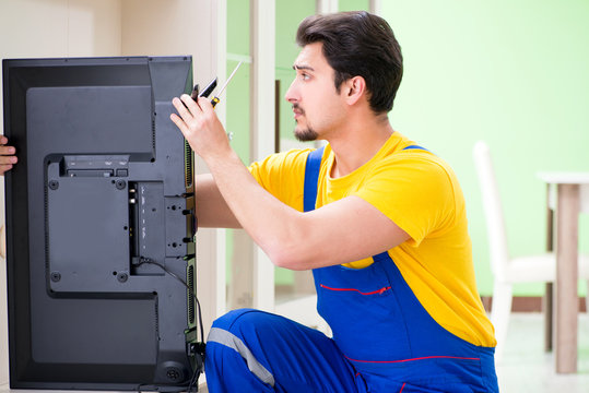 Male professional serviceman repairing tv at home