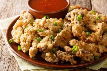 Stoff pro Meter crispy fried chicken gizzards with a deep, rich, meaty flavor that are sliced in twisted bits and fried to perfection close-up on a plate. horizontal © FomaA