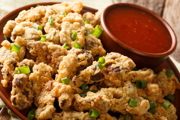 deep fried chicken gizzards in breadcrumbs with chili sauce close-up. horizontal