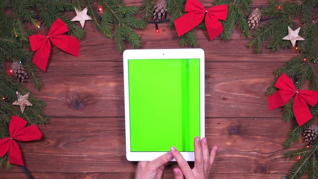 Man fingers scrolling pages on tablet with green screen