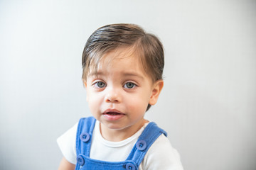 Naklejka premium Cute baby boy toddler - with blue romper on white background