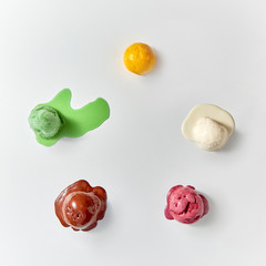 Flat lay of colorful ice cream - vanilla, chocolate, berry, mango, mint. Ice cream balls melted on...