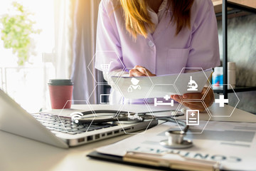 Medical Technology Concepts The doctor is working on a tablet and audio player and a digital tablet computer in a modern office with coffee in the morning at the desk.