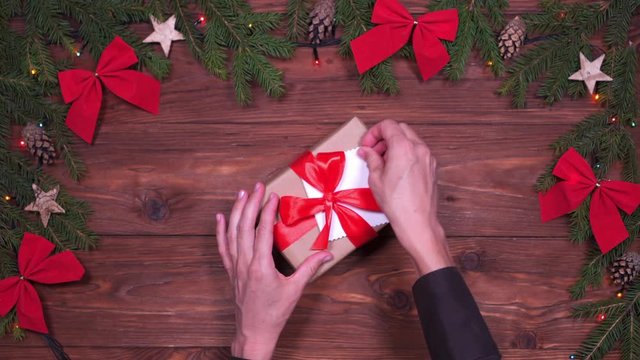Hands untying satin ribbon of pretty Christmas gift box