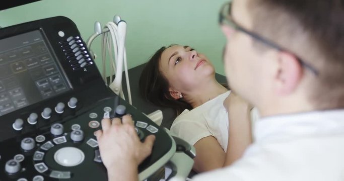 A young woman lies on a couch in the ultrasound diagnostic room.