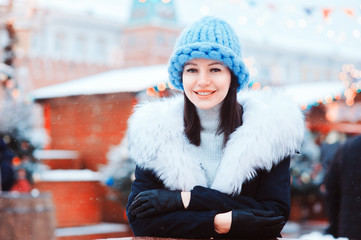 happy girl on christmas shopping at winter snowy Moscow city holiday market, buying souvenirs and gifts, New Year shopping concept