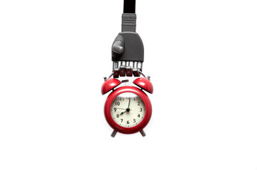 Toy robot hand is holding a red alkarm clock isolated on white background. Digital reminder.
