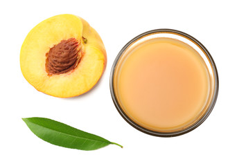 glass of peach juice with peach fruit, green leaf and slices isolated on white background. top view