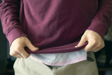 Obraz na płótnie Canvas close up male put on dress casual sweatshirt at home near wardrobe g