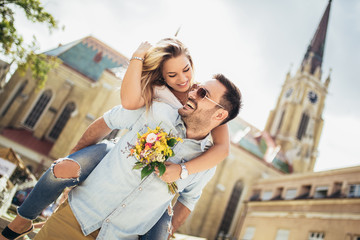 Picture of young man surprising woman with flowers