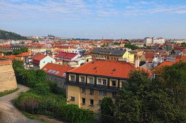 Fototapeta na wymiar Aerial view of residential district in Prague. Buildings with red tile roofs, a lot of trees. Colorful vibrant sky. Summer landscape photo on a sunny morning. Prague, Czech Republic