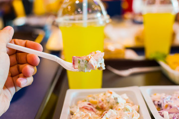 salad in a plastic container with a fork