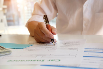 Insurance concept Pen on hand with a man sing insurance contract.