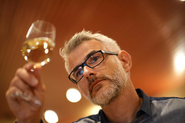 Winemaker tasting white wine in cellar