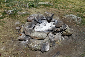 Extinct camp fire place surrounded with rocks or stones, photo of nature