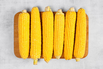 Pilled fresh corn cobs on the textured grey table
