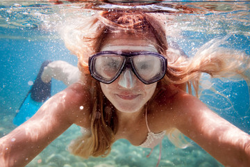 Naklejka premium Beautiful woman underwater snorkeling in the clear tropical water