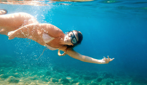 Beautiful woman underwater snorkeling in the clear tropical water