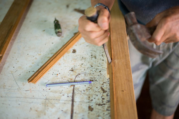 Hands of technicians at work repairing woodwork.