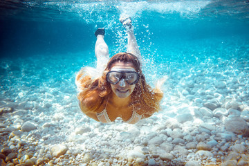Naklejka premium Girl snorkeling underwater in the tropical sea