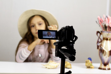 close-up video camera, a beautiful child tells about the vacation, blogger holding a shell, focus on the foreground