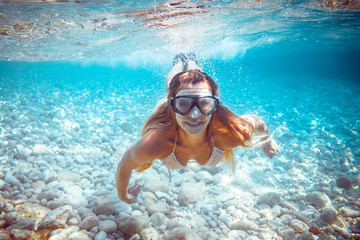 Naklejka premium Girl snorkeling underwater in the tropical sea