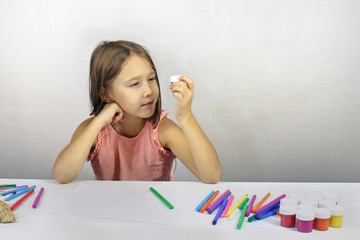 child draws with markers and paints, looking for the concept of creativity