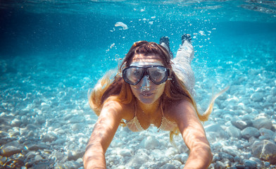 Naklejka premium Girl snorkeling underwater in the tropical sea