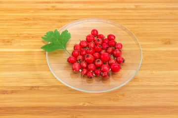 Fruits and leaf of the hawthorn on glass saucer