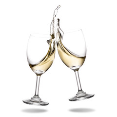 Cheers white wine with splash out of wineglass isolated on white background.