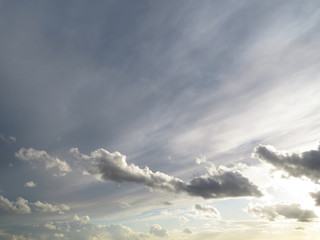 Obraz premium White and gray clouds in the sky. Weather background, sky after storm, sun is shining through the clouds