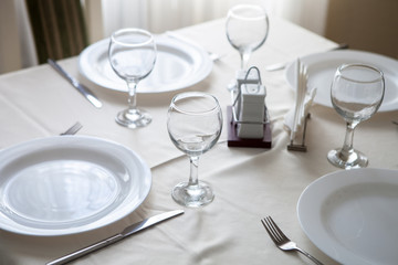 Glasses and glasses for wine on a table with a white tablecloth in a restaurant
