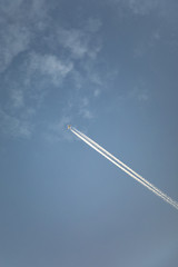 aircraft with contrail in morning sun