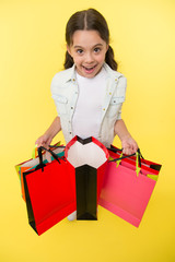 Check out her profitable purchases. Girl carries shopping bags yellow background. Girl fond of...