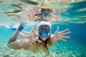 Woman snorkeling with full face mask in the tropical sea - obrazy, fototapety, plakaty